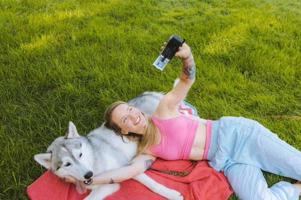 A pet parent taking a photo with her dog