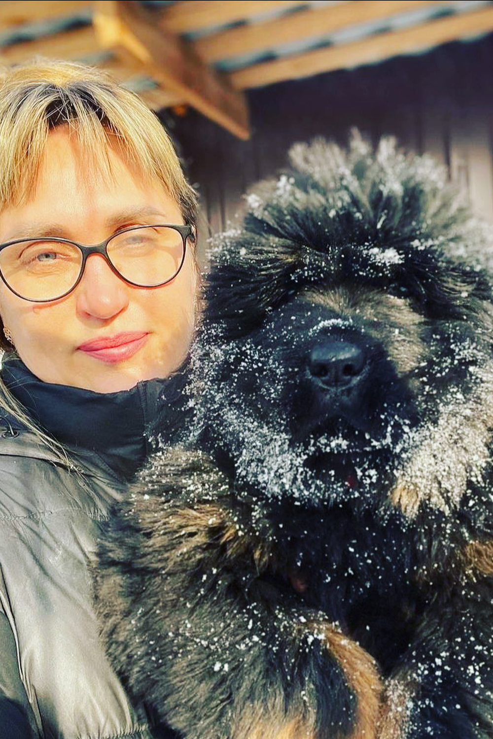 Tibetan Mastiff with her owner on snow