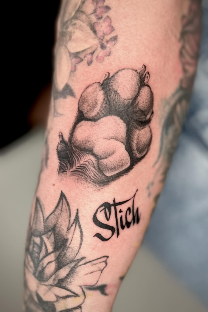 A person's arm showcasing a realistic paw print tattoo