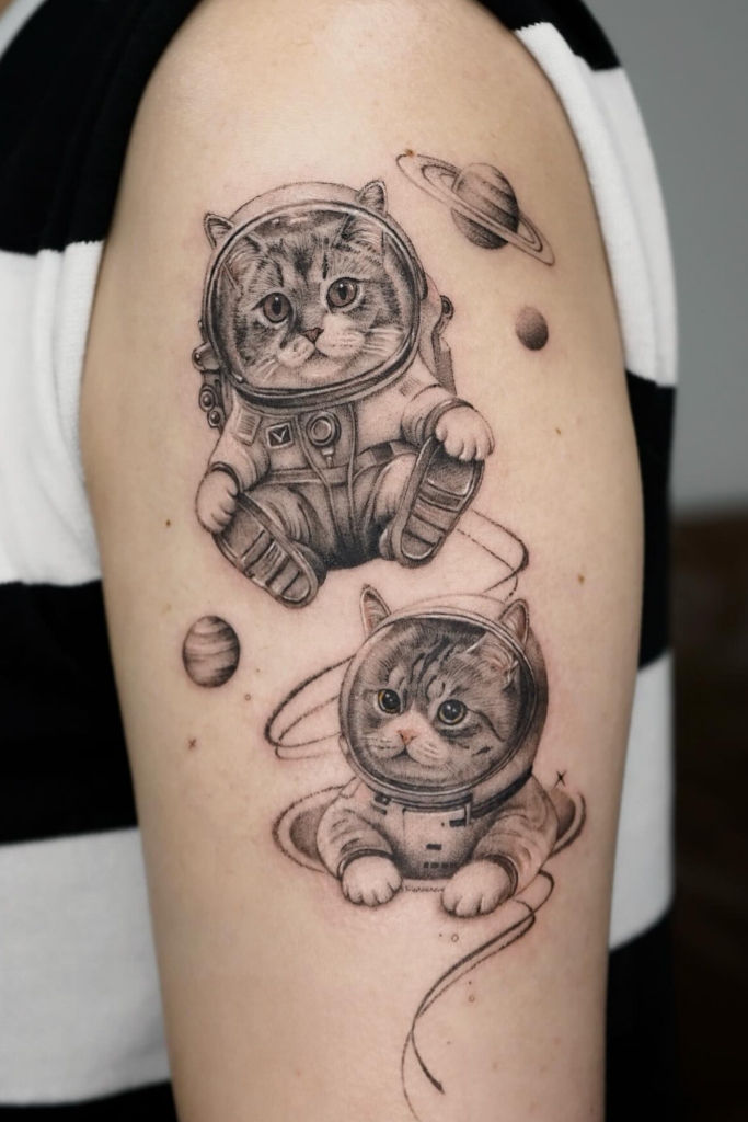A person's arm with two cats tattoos