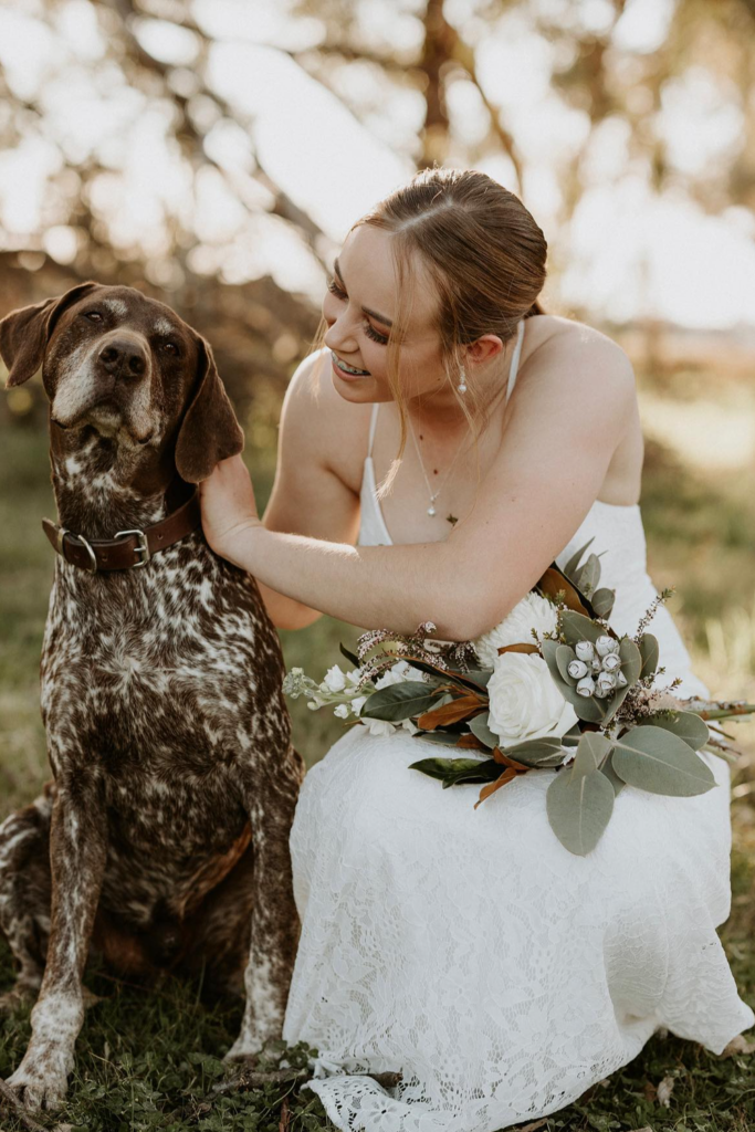 A photo of a woman with a wedding gown besides a large breed dog