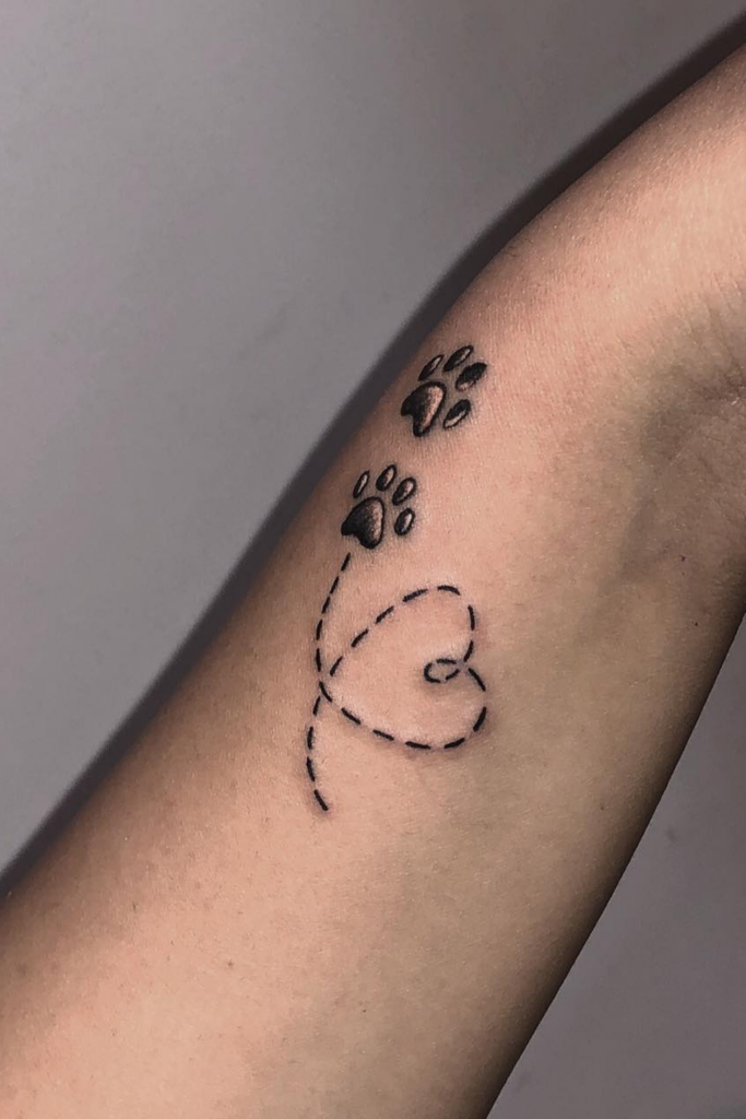 An arm with two paw prints and a heart tattoo
