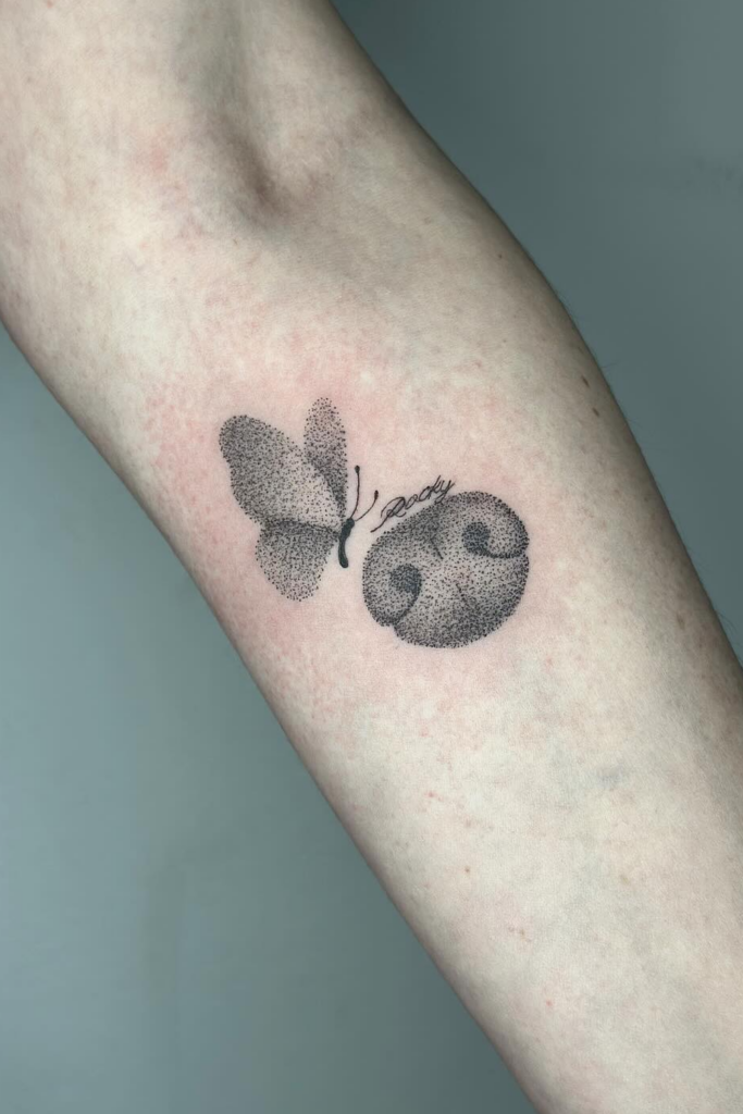 Arm tattoo of a dog's nose and a cute butterfly