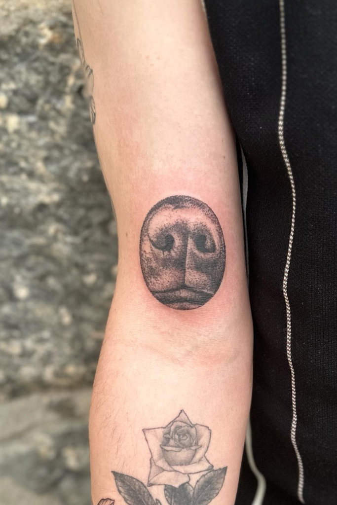 Arm tattoo of a dog nose