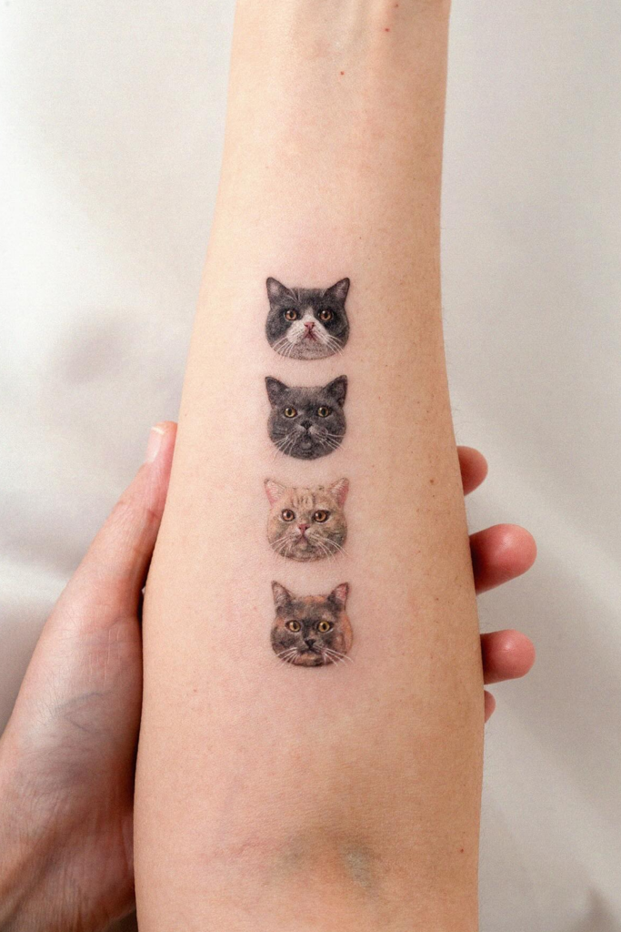 A person holding a leg with a beautiful tattoo of four cat faces