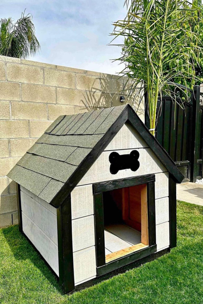 A small wooden doghouse on a green backyard