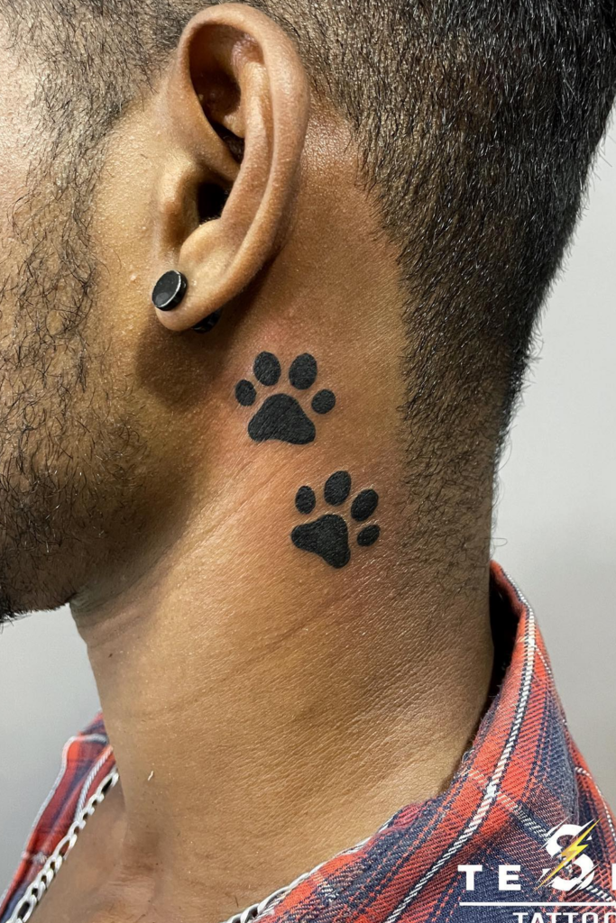 Two black paw print tattoos on the left side of a person's neck.