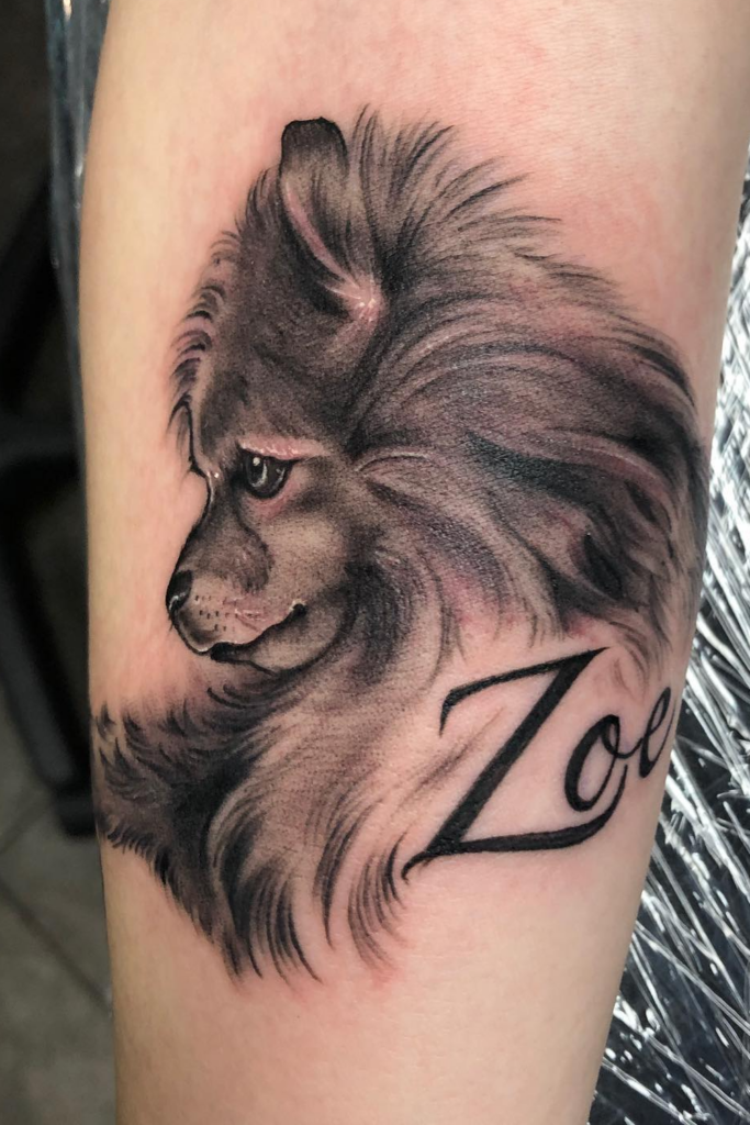 Realistic dog memorial tattoo of 'Zoe', featuring detailed fur and expressive eyes.