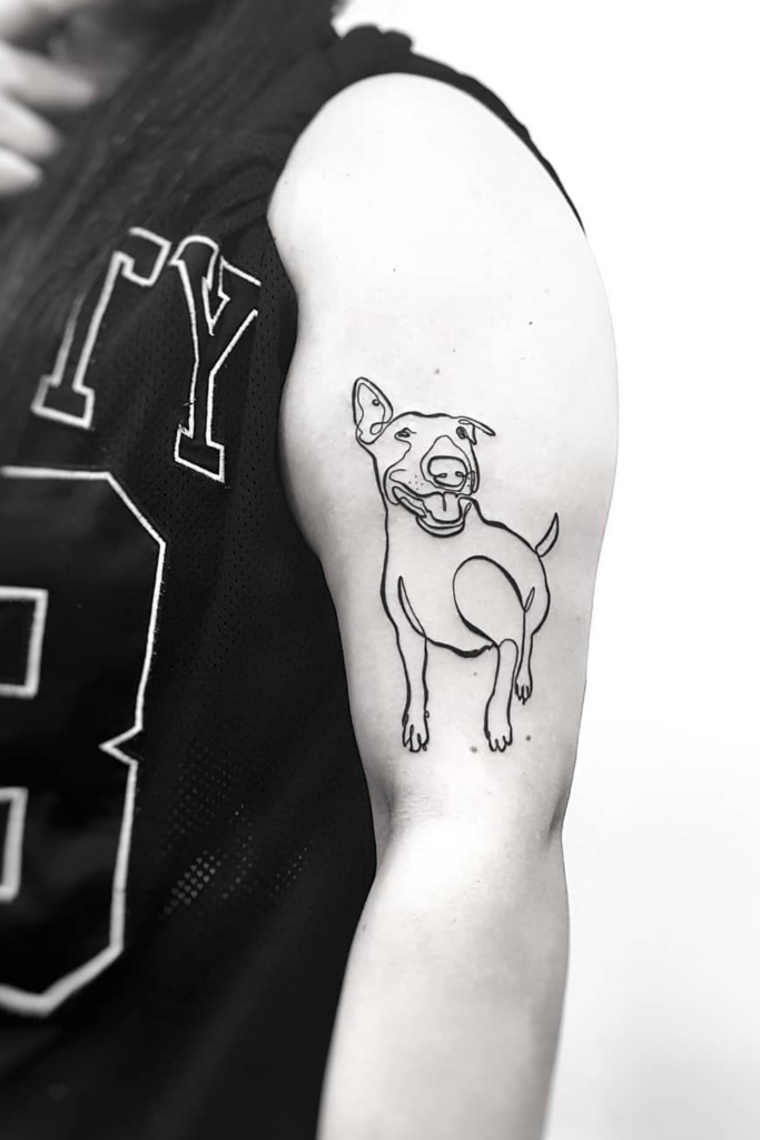 Tattoo of an adult dog on the upper left arm